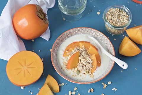 Schale mit Naturjoghurt mit Müsli und Kaki, lizenzfreies Stockfoto