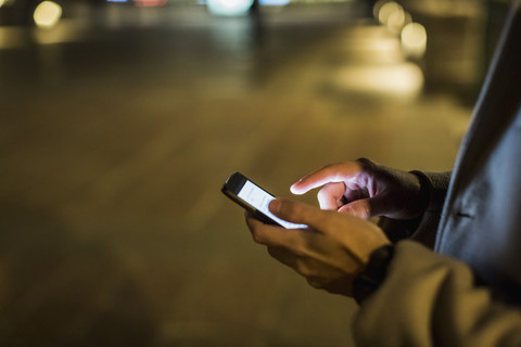 Mann im Freien bei Nacht mit Mobiltelefon, lizenzfreies Stockfoto