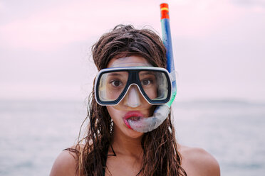 Young woman with diving goggles and snorkel pulling funny faces - WVF00780