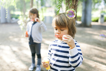 Jungen blasen Seifenblasen im Park - VABF01015