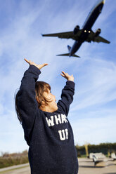 Boy reaching for landing airplane - VABF01020