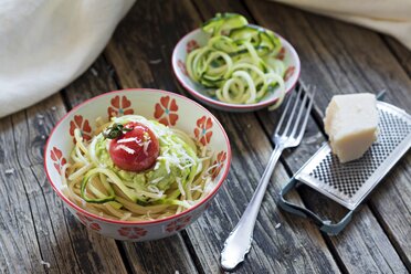 Schüssel mit Spaghetti, Zucchini-Spaghetti, Guacamole, Kirschtomaten und geriebenem Parmesan - YFF00613