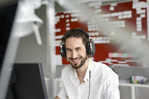 Smiling man in office with headset stock photo