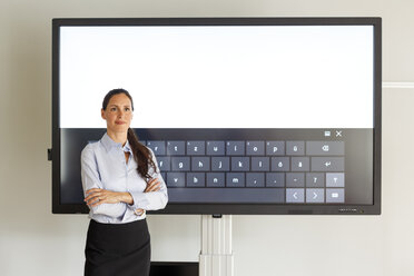 Geschäftsfrau vor der Projektion einer Tastatur stehend - PESF00414