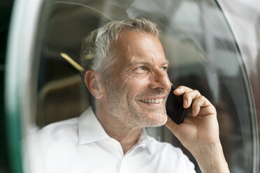 Lächelnder Geschäftsmann am Mobiltelefon - PESF00428