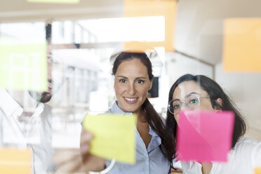 Thre colleagues in modern office working with adhesive notes - PESF00430