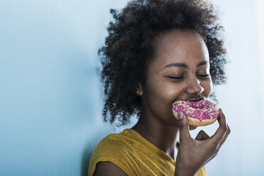 Portrait of young woman eating doughnut - UUF09779