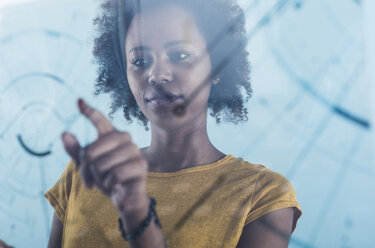 Young woman using transparent touchscreen display - UUF09782