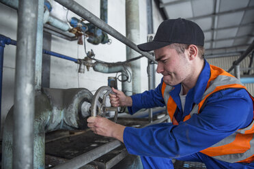 Arbeiter dreht Ventil in Fabrik - ZEF12408