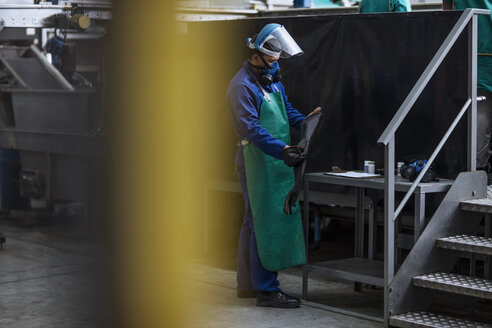 Arbeiter mit Schutzmaske in einer Fabrik - ZEF12423
