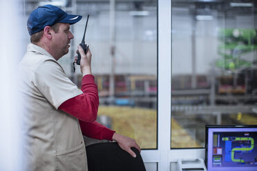 Arbeiter mit Walkie-Talkie instruiert Team - ZEF12433