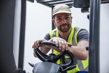 Portrait of confident man on forklift - ZEF12444