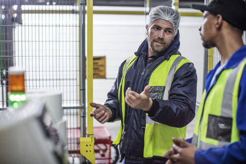 Two workers discussing in factory stock photo