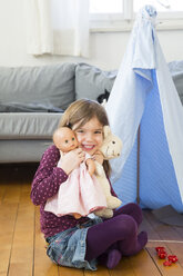 Porträt eines glücklichen kleinen Mädchens mit ihrem Spielzeug zu Hause - LVF05792