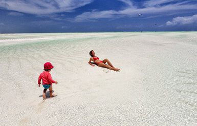 Tansania, Insel Sansibar, Paje, Mutter und kleine Tochter entspannen sich bei Ebbe am Strand - DSGF01426