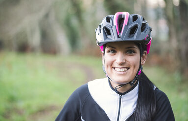 Porträt einer lächelnden Frau mit Fahrradhelm - RAEF01656