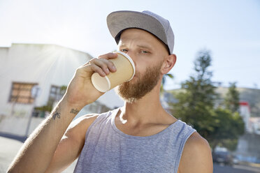 Porträt eines jungen Mannes, der Kaffee zum Mitnehmen trinkt - SRYF00200