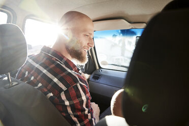 Lächelnder junger Mann auf dem Beifahrersitz in einem Auto - SRYF00209