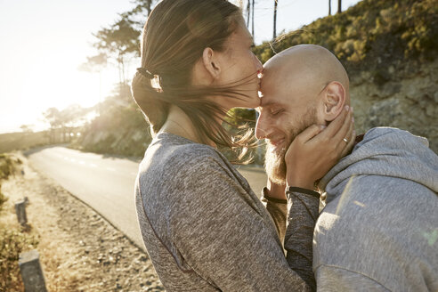 Young woman kissing husband on his forehead - SRYF00232