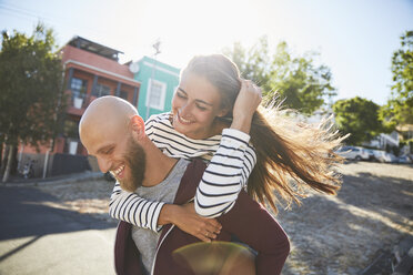 Young man giving his girlfriend a piggyback ride - SRYF00244