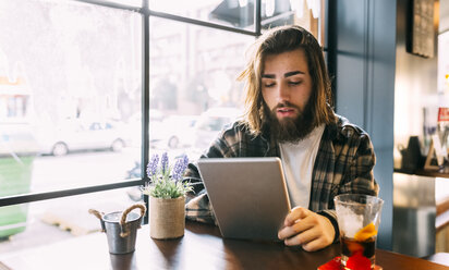 Stilvoller junger Mann mit Tablet in einem Café - MGOF02813