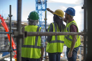 Bauarbeiter im Gespräch mit Mann und Frau auf einer Baustelle - ZEF12466