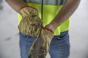 Construction worker putting on protective gloves - ZEF12471