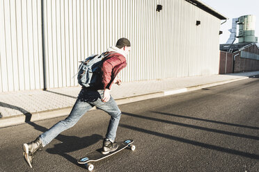 Junger Mann fährt Skateboard auf der Straße - UUF09856