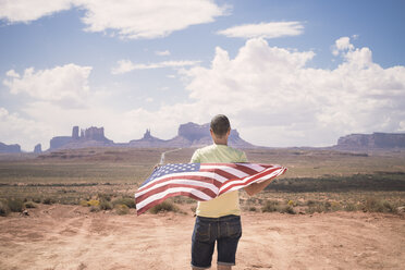 USA, Utah, Rückenansicht eines Mannes mit amerikanischer Flagge mit Blick auf das Monument Valley - EPF00278