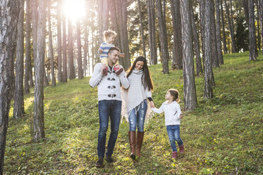 Happy family with two girls walking in forest - HAPF01295