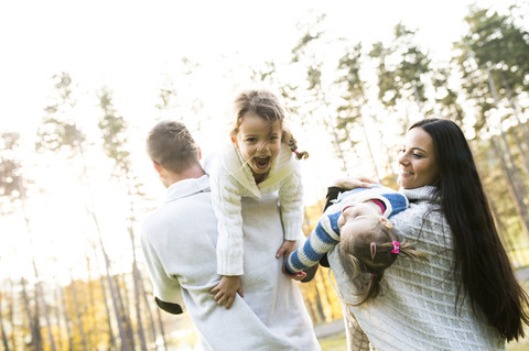 Verspielte Familie mit zwei Mädchen im Freien, lizenzfreies Stockfoto