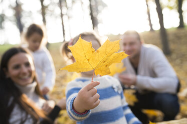 Mädchen mit ihrer Familie hält Herbstblatt - HAPF01314
