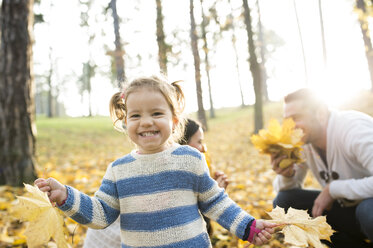 Glückliches Mädchen mit Familie im herbstlichen Wald - HAPF01315