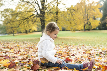 Girl sitting in autumn leaves - HAPF01319