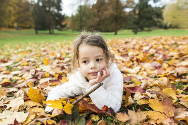 Girl lying in autumn leaves - HAPF01326