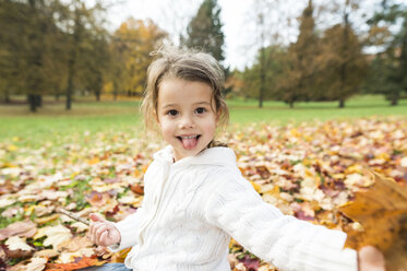 Portrait of playful girl in autumn leaves - HAPF01327