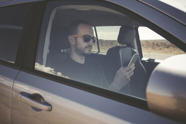 Mann in einem Auto mit Smartphone - EPF00285