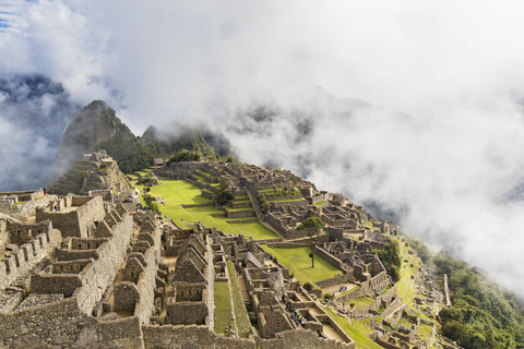 Peru, Anden, Urubamba-Tal, Machu Picchu mit Berg Huayna Picchu in Nebel und Wolken, lizenzfreies Stockfoto