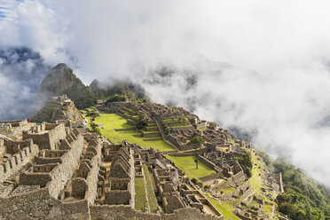 Peru, Andes, Urubamba Valley, Machu Picchu with mountain Huayna Picchu in fog and clouds - FOF08766