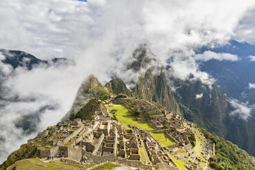 Peru, Andes, Urubamba Valley, Machu Picchu with mountain Huayna Picchu in fog and clouds - FOF08773