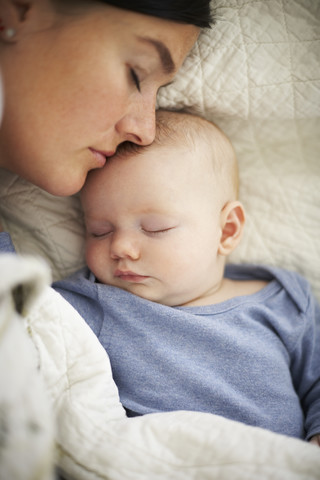 Mutter und Baby schlafen im Bett, lizenzfreies Stockfoto