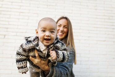 Glückliche Mutter mit Baby an der Backsteinmauer - VABF01032