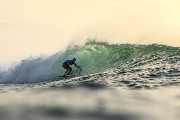 Indonesien, Bali, Mann surft auf einer Welle - KNTF00616