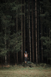 Junger Mann steht vor einem Nadelwald - WVF00811