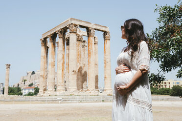 Griechenland, Athen, schwangere Frau beim Besuch des Olympieions mit der Akropolis im Hintergrund - GEMF01415