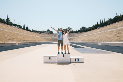 Griechenland, Athen, Paar auf dem Podium beim Feiern im Panathenäischen Stadion, lizenzfreies Stockfoto