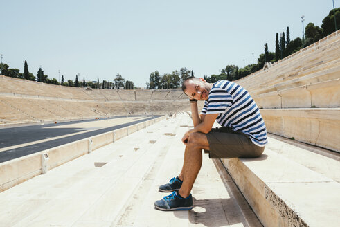 Griechenland, Athen, Mann sitzt auf der Tribüne des Panathenäischen Stadions - GEMF01421