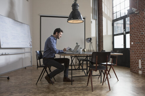 Geschäftsmann arbeitet am Laptop im Büro - RBF05572