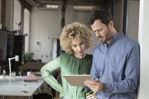 Man and woman looking at tablet in office - RBF05582