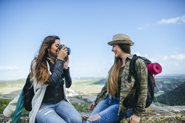 Zwei glückliche junge Frauen auf einer Reise, die ein Foto machen - KIJF01113